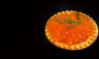 red caviar in a tartlet on a black background