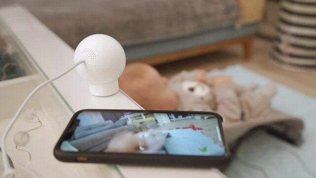 Home security camera works in living room, using ip camera as baby video monitor on mobile phone, watching live stream on smartphone screen. High quality 4k footage