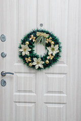 wreath on the background of a white door. Christmas. Holiday.
