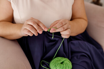 Woman knits a toy to decorate the Christmas tree.