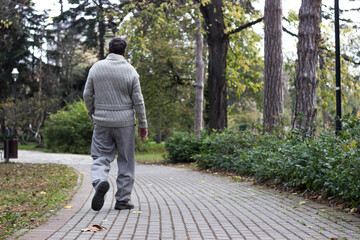 Fototapeta premium Senior man walking and relaxing in park
