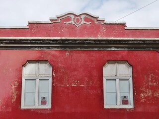 Altbau mit Verzierung, roter Fassade und Fenstern