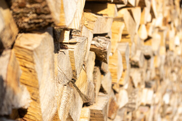 Front eines Holzstapels aus gehacktem und ordentlich aufgeschichtetem Scheitholz und Kleinholz zum Trocknen für Kaminholz und Brennholz seitlich fotografiert mit kleinem Fokusbereich