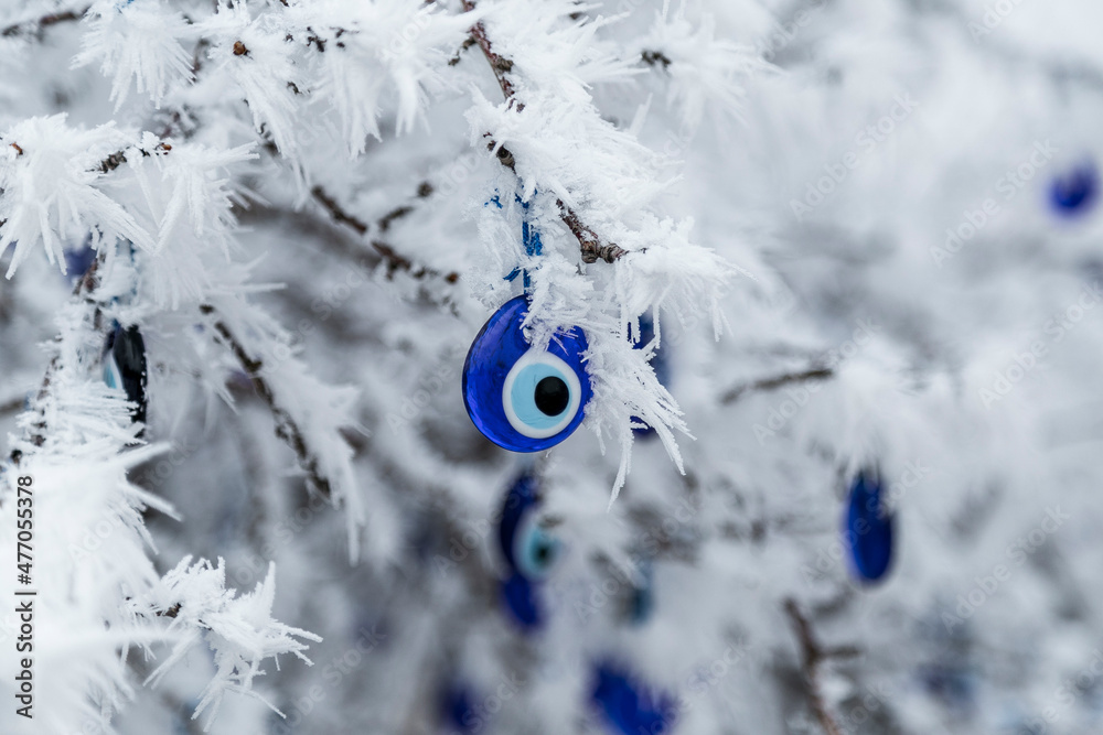 Wall mural blue evil eye, nazar boncugu, turkish symbols hanging on a tree; cappadocia