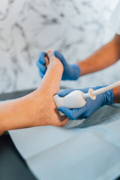 Close-up of a chiropodist doing an ultrasound test to patient's foot.