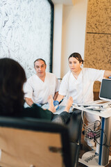 Chiropodist doing an ultrasound test to patient's foot.