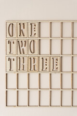 the numbers 1,2,3 spelled out in wooden stencil font inside a grid