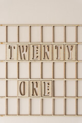 the number 21 spelled out in wooden stencil font inside a grid