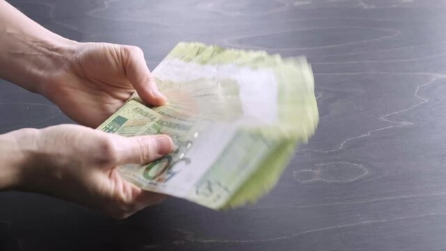 4K. Close-up view of hands wave fan out the stack of belarusian 50 ruble paper money. A lot of cash. Saving. National currency of Belarus. Pay of credit liabilities. Salary. Big debt. Tax payment.
