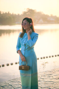 beautiful asian woman wearing thai tradition clothes standing outdoor against morning light