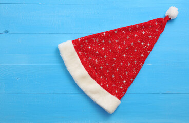 Santa hat with stars on blue wooden background