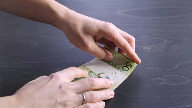 Close-up view. Move of stack of belarusian 50 ruble paper money. Bet. Hands hold a lot of cash. Saving. National currency of Belarus. Pay of credit liabilities. Salary concept. Big debt. Tax payment.