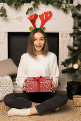 The young girl is happy to receive a red Christmas gift