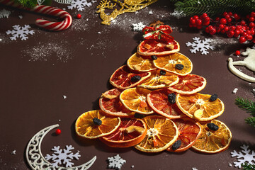 Obraz na płótnie Canvas Festive fir tree from dried fruits. Christmas or New Year festive flat lay, food creative