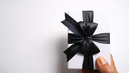 A man's hand gives a gift box with a ribbon on a white background. Valentine concept, New year Concept, Christmas Concept. Top view, Anniversary Concept. High angle view, Flat Lay.
