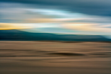 Sunset over sand dunes abstract background. Mountains and colorful cloudy sky on background