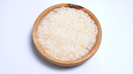 Fototapeta na wymiar Rice in a wooden bowl with some neat and simple kitchen ornaments giving an elegant and attractive impression. food and beverage concept. rice is a symbol of prosperity.