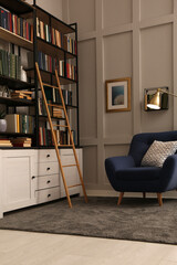 Cozy home library interior with collection of different books on shelves and comfortable place for reading © New Africa