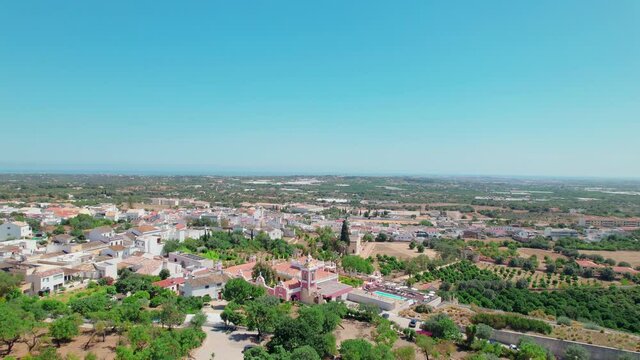 Portuguese historical village on a sunny day with traditional houses from above. Roman Ruins of Milreu and Estoi Palace / Pousada Pal&aacute;cio Est&oacute;i Resort Hotel with pool in 4K. 