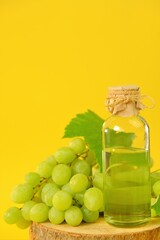 Grape seed oil.Base cosmetic oil for massage and care for face and body. bottle and green grapes on a bright yellow background.Organic Natural Bio Grape Seed Oil.natural cosmetics