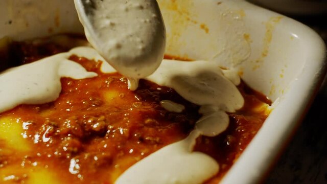 Placing white milk and cream sauce on top of a homemade european lasagne food