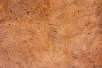 Beige brown exterior plaster wall texture background with scratch and crack pattern