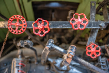Red knobs to control gears and pipes on a vintage train engine.
