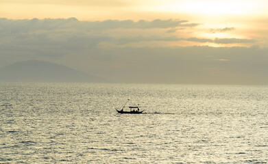 Naklejka premium A gorgeous sunset over the Pacific Ocean with silhouette shots of fishing boats. 