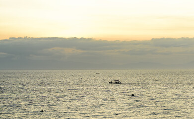 A gorgeous sunset over the Pacific Ocean with silhouette shots of fishing boats. 