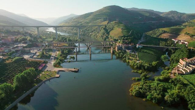 Scenic aerial view of Vila Real District along the Douro Valley River with bridges. Stunning massive Ponte Miguel Torga and R&eacute;gua Pedestrian Bridge with the beautiful green town by the river in 4K.