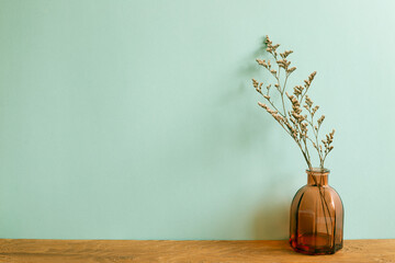 Vase of dry flowers on wooden table. mint wall background. home interior