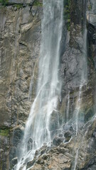 The beautiful countryside view with the waterfall flowing in the mountains after the rainy day
