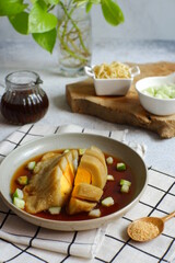 a plate of pempek served with sauce named cuko, its an indonesian cuisine made from fish and tapioca flour 
