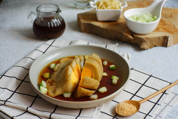 a plate of pempek served with sauce named cuko, its an indonesian cuisine made from fish and tapioca flour 