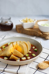 a plate of pempek served with sauce named cuko, its an indonesian cuisine made from fish and tapioca flour 
