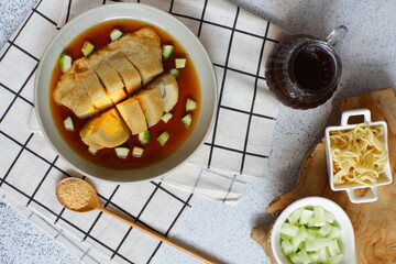 a plate of pempek served with sauce named cuko, its an indonesian cuisine made from fish and tapioca flour 
