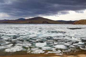 Spring landscape of Lake Baikal on a cloudy day. Ice drift, ice floes in the lake. © Viktoriya
