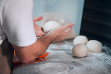 Chef shaping dough in to small balls and letting it rise