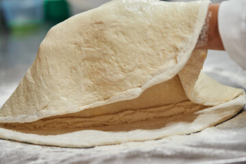 Dough being tossed and stretched by chef