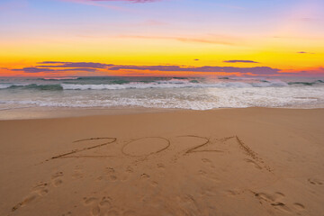 Text 2021 Lettering on the beach with waves and sunset sky Numbers 2021 year on the seashore, Message hand written in the golden sand on beautiful sunset or sunrise golden sky background