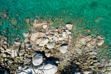 Aerial view Top down seashore Wave crashing on rock cliff Beautiful sea surface in sunny day summer background Amazing seascape top view seacoast at Phuket Thailand