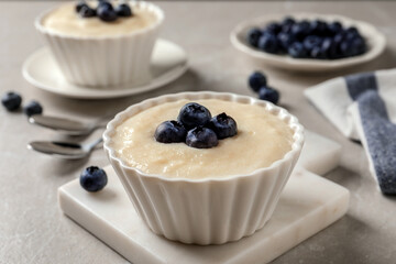 Delicious semolina pudding with blueberries on white table