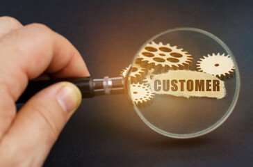 In his hand is a magnifying glass through which you can see the gears and scrap of paper with the inscription - CUSTOMER