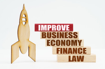 On the white surface there is a wooden rocket and planks, on the red plaque the inscription - IMPROVE