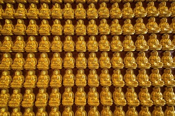 Bangkok, Thailand - December, 20, 2021 : Many golden buddha statues arrange by row and column at...