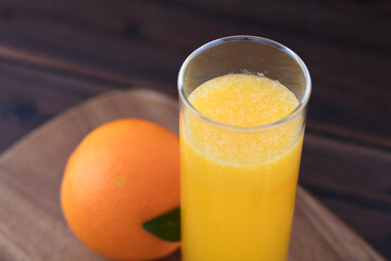 A glass of orange juice and an orange