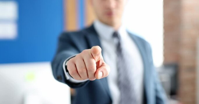 Businessman in business suit points his finger forward