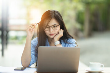 Asia Woman is working on the personal computer and smartphone at work from home