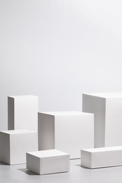 Abstract minimal scene - empty stage with six rectangle podiums on white background and soft window shadows. Pedestal for cosmetic product and packaging mockups display presentation
