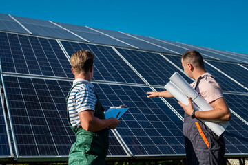 Two professional contractors discuss final result at solar panel installation